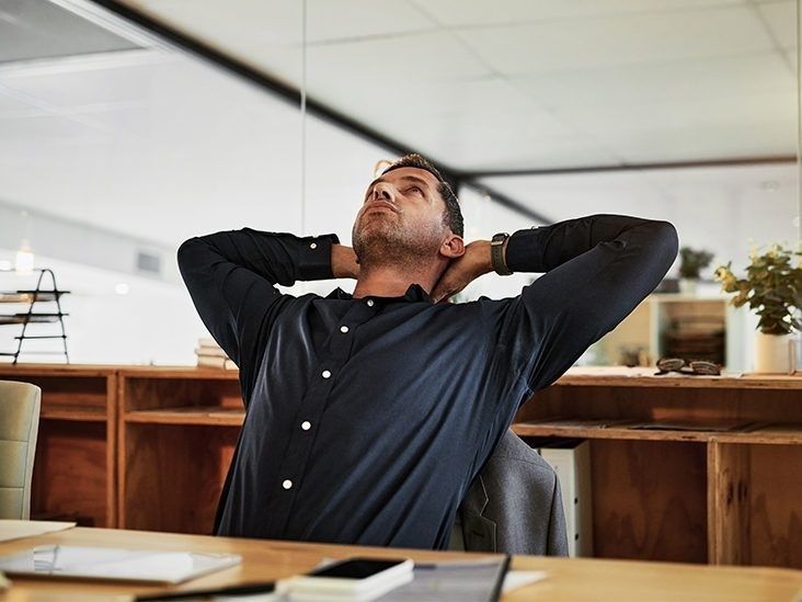 Man lutar sig tillbaka och sträcker axlarna vid ett skrivbord